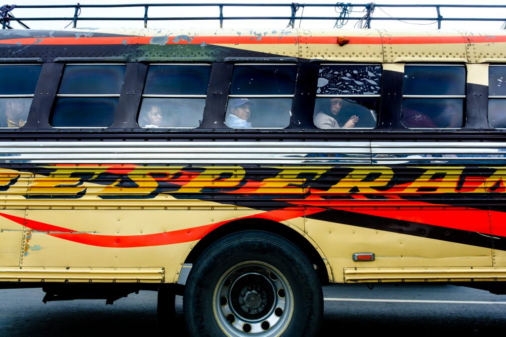 Passengers boarding a colorful chicken bus in Guatemala