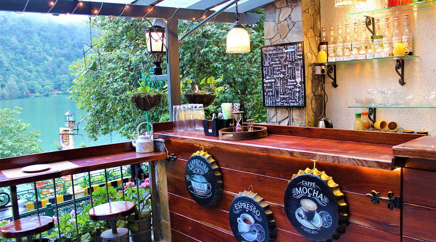 Tourists enjoying a meal at a lakeside restaurant, example of mid-range Lake Atitlan cost and dining budget.
