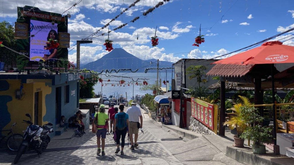 Tourists with luggage walking toward the Panajachel dock to catch boats around Lake Atitlan